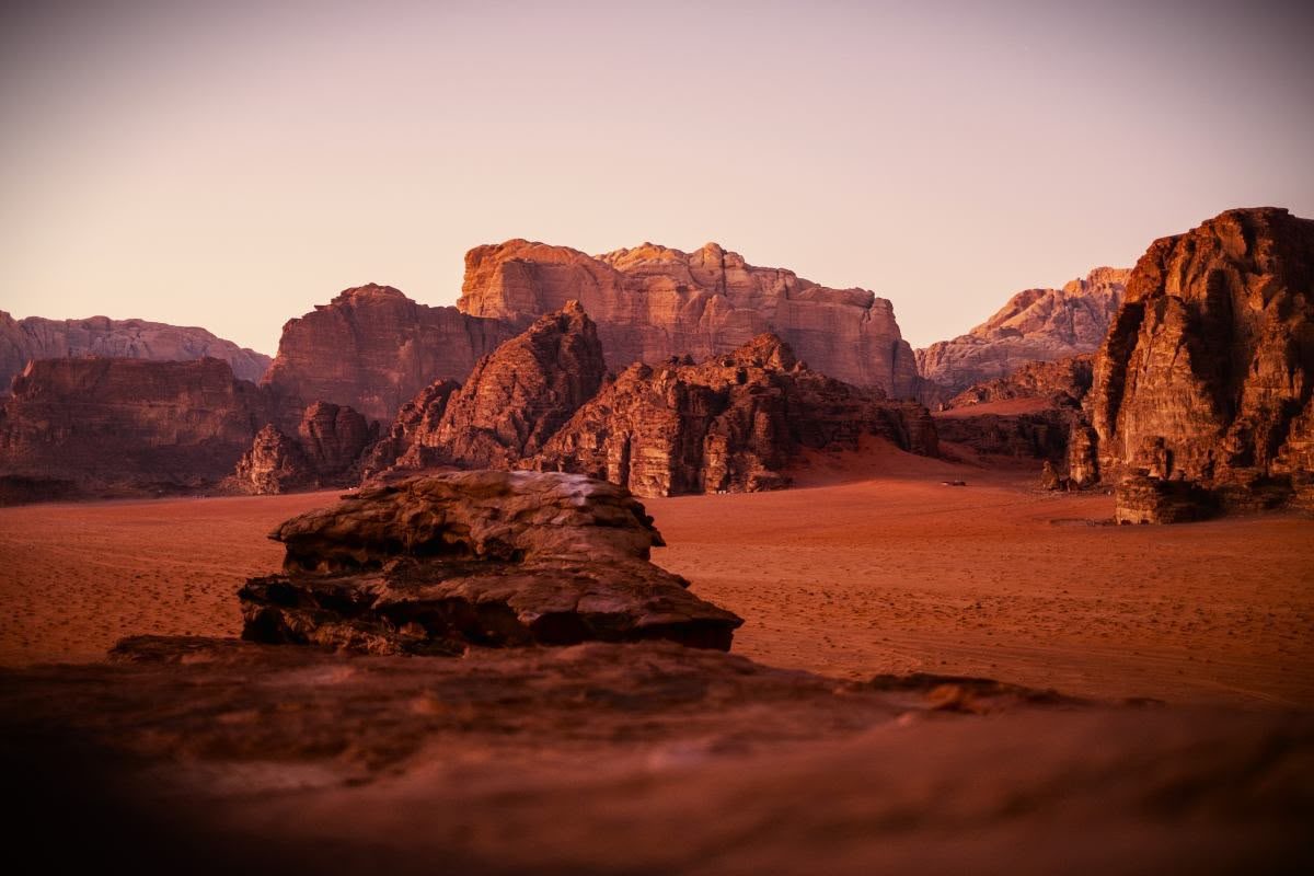 Red sand and sandstone mountains in Wadi Rum at dusk